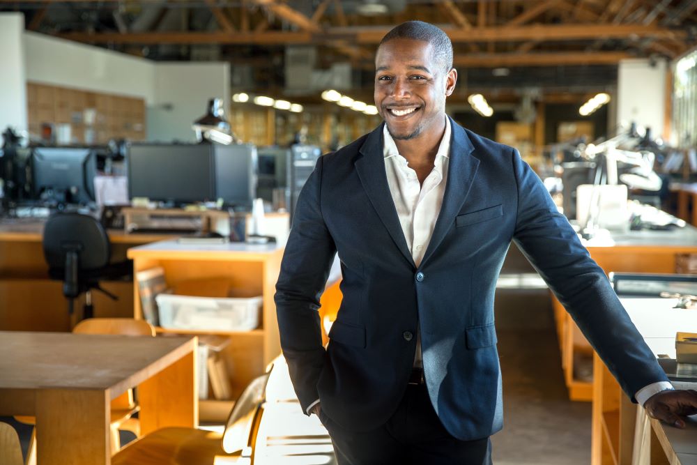 Business owner in his office smiling at a camera 
